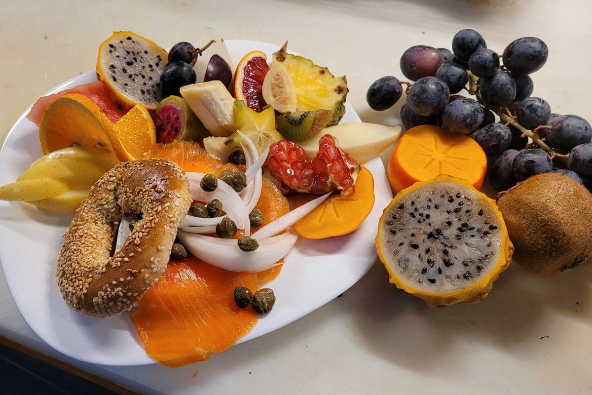 Bagel au fromage à la crème, Lox, câpres, oignons et fruits frais / Cream Cheese Bagel with lox, capers, onions, and fresh fruit